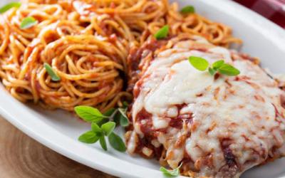Chicken Parmesan and pasta served on a plate.