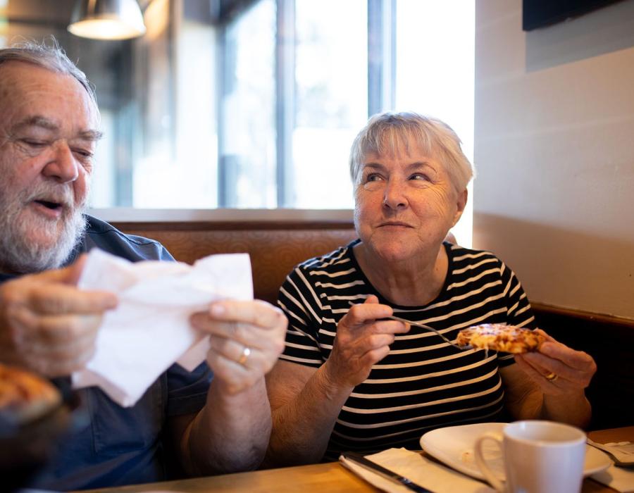 Man and woman eating pizza